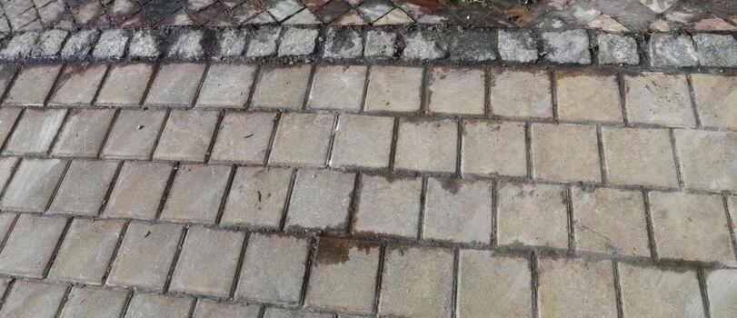 Detailed View of Textured Pavement With Wet Patches in an Outdoor Setting During a Cloudy Afternoon photo