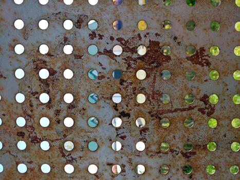 Perforated Metal Wall Showcasing Texture, Rust, and Reflections From a Vibrant Environment photo