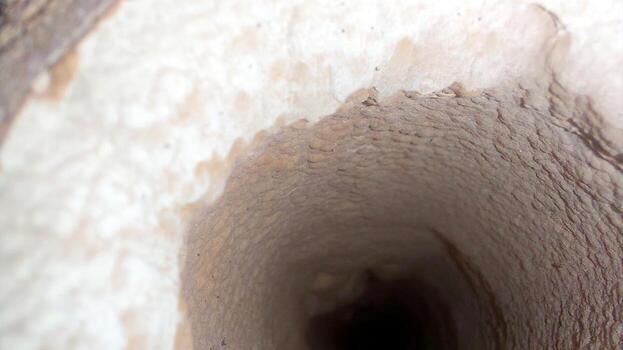 Thick Layer of Limestone Inside a Rugged Pipe in a Geological Formation photo