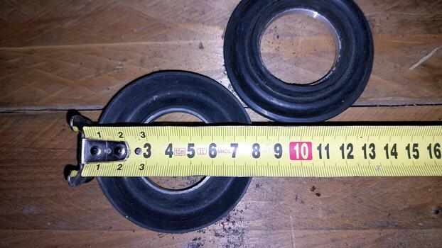 Measurement of pump seal collar on wooden surface with tape measure photo