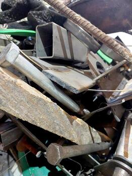 Scrap Metal Piled High in a Recycling Yard Showing Various Materials During the Late Afternoon photo