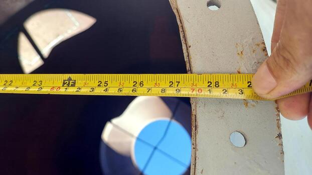 A person measuring the diameter of a pipe photo