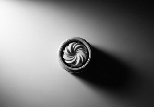 Overhead shot of a white cupcake with swirl frosting in a dark studio setting photo