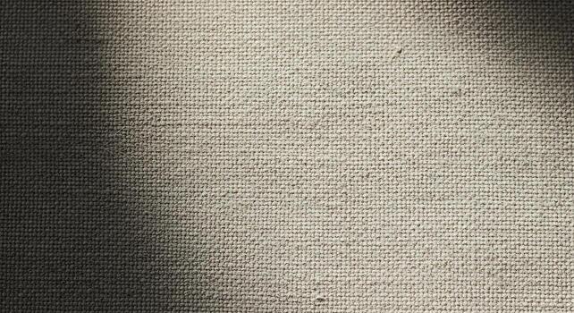 Close up textured fabric surface with subtle light and shadow patterns creating a minimalist aesthetic photo