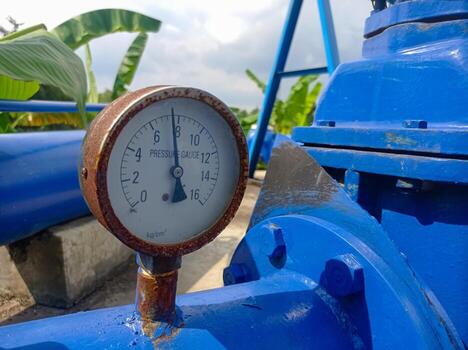 Industrial pressure gauge on blue pipeline photo