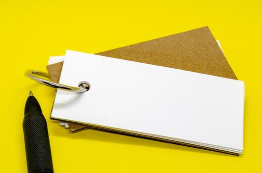White banner shape notepad with customizable space for text on yellow background with black pen.. photo