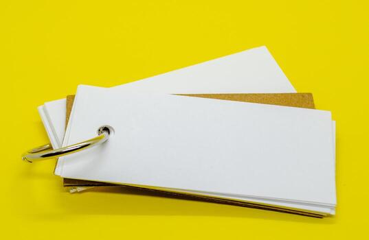 Close up of white banner shape notepad with customizable space for text on yellow cover background. Copy space concept. photo