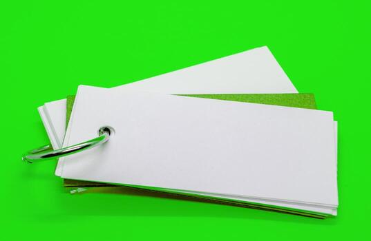 Close up of white banner shape notepad with customizable space for text on green cover background. Copy space concept. photo