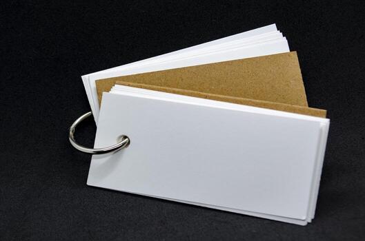 Close up of white banner shape notepad with customizable space for text on black cover background. Copy space concept. photo