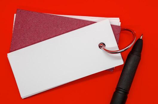 White banner shape notepad with customizable space for text on dark red cover background. Copy space. photo