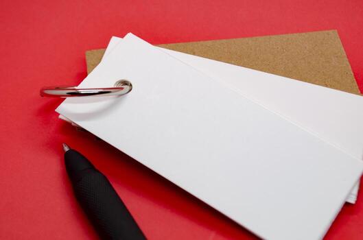 Close up of white banner shape notepad with customizable space for text on red cover background. photo