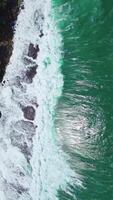 Aerial Drone View of Ocean Waves Crashing on Coastline, Vertical 4K Stock Footage. Vertical drone shot of powerful ocean waves rolling on coastline, nature stock video