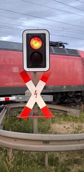 A red traffic light at a railroad crossing. A warning sign and a speeding train. photo