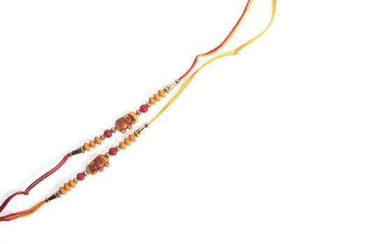 Decorative wooden bead strings with red and yellow threads isolated on white photo