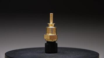 reserv del. ny motor kylmedel temperatur sensor. roterande ny del på en lutning bakgrund. grund djup av fält. video