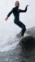 An Exciting Session of Surfing. A Passionate Surfer Mastering Waves with Skill and Determination while Riding Through Choppy Waters on a Cloudy Day video