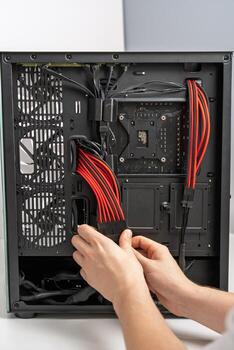 un tecnología entusiasta conecta poder suministro cables dentro un moderno computadora caso durante un personalizado ordenador personal construir. esta imagen vitrinas computadora montaje y tecnología aficiones. foto