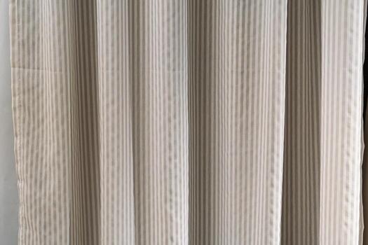 Close-up of textured ticking stripe fabric in neutral tones, ideal for backgrounds in interior design or textile mockups. A versatile pattern for various creative projects. photo
