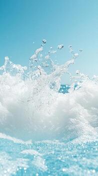 Clear blue water breaks upward. Sparkling drops fly against a bright sky. A refreshing splash with cool tones and gentle waves. photo