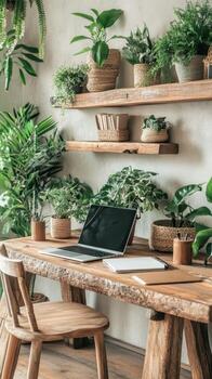 Rustic wooden desk with open portable computer and plants against a white wall. Green plants in pots on desk and shelf. Interior design. photo