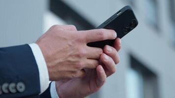 detailopname mannetje handen Holding mobiel telefoon in stad onherkenbaar bedrijf Mens chatten met smartphone apparaat onbekend zakenman met mobiele telefoon Bezig met verzenden sms bericht gebruik makend van online cyberspace internet video