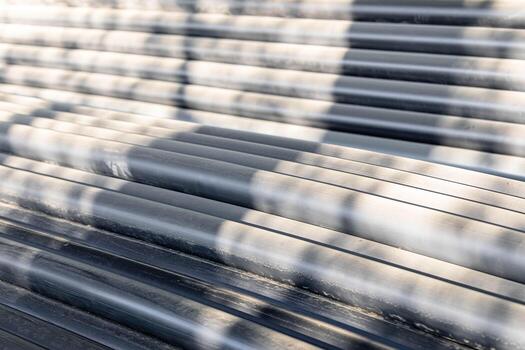 Textured surface of stack of plastic pipes with shadows creating abstract patterns and depth photo