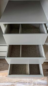 Top view of the open drawers with gray organizers built into a white wardrobe. Sorting and organizing. photo