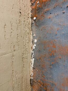 Peeling paint revealing layers of textured concrete and original orange color, creating rustic and aged surface showing decay and deterioration on wall. Decorative for design photo