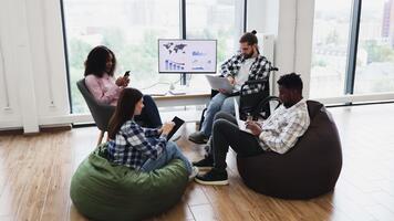 jovem adultos do diferente sexos e etnias trabalhando juntos com laptops, feliz, casual video
