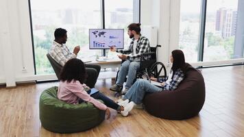 diverso grupo do jovem adultos discutindo global financeiro relatório em monitor dentro moderno escritório video