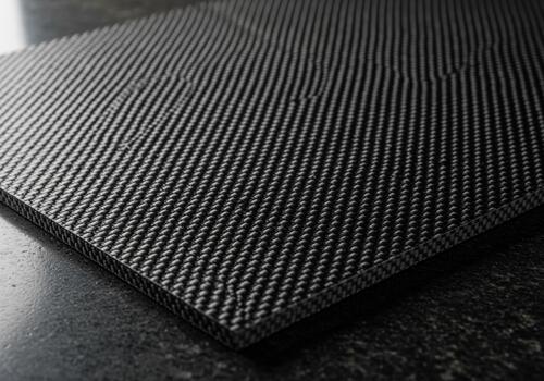 Detailed black carbon fiber composite sheet texture with diagonal twill weave pattern photo