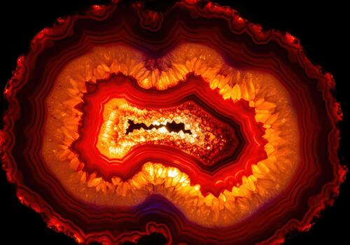 Vibrant abstract pattern of a backlit red agate slice with quartz crystals photo