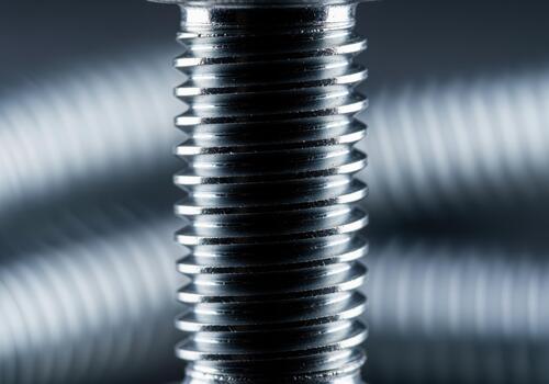 Extreme close up view of shiny metallic bolt threads showing precision engineering photo