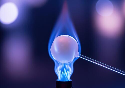 Ethereal white sphere heated by a brilliant blue laboratory flame during experiment photo