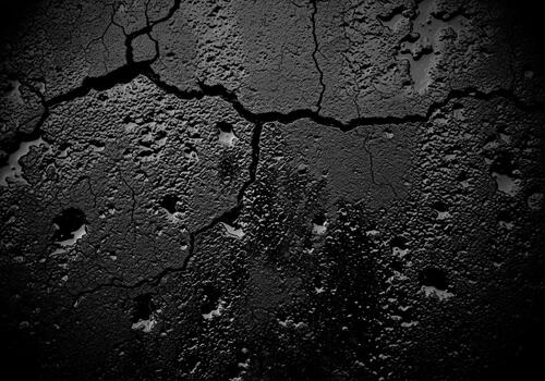 Dramatic dark cracked texture background resembling wet asphalt or distressed concrete surface photo