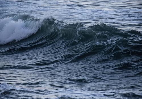 Powerful dark ocean wave cresting and foaming, showing the raw energy of the sea. photo