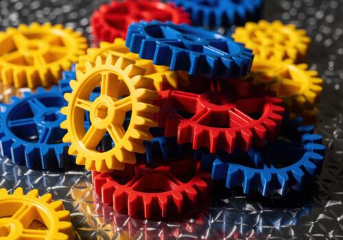 Stack of colorful plastic gears red yellow blue representing teamwork and engineering concept photo