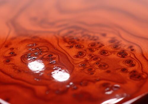 Abstract macro view of glossy red cherry wood burl texture and complex swirling patterns. photo