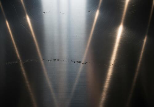 Dark brushed metal texture background featuring bright diagonal light reflections. photo