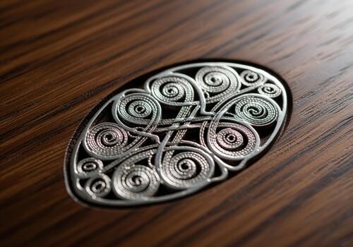 Detailed silver filigree scrollwork inlay set into polished dark walnut wood grain. photo