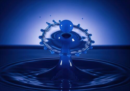 Blue liquid drop collision captured in high speed photography creating a perfect crown photo