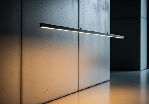 Sleek linear LED pendant light illuminating a textured concrete wall in a modern architectural space photo