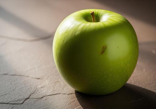 Vibrant green apple close up on dark slate surface illuminated by dramatic light photo