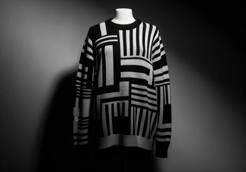 Striking geometric black and white sweater displayed on a mannequin in studio. photo