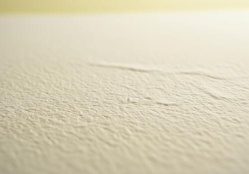 Detailed macro photograph of rough cream watercolor paper surface texture photo