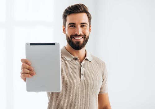 Confident bearded man showing a blank digital tablet screen for presentation or mockup photo