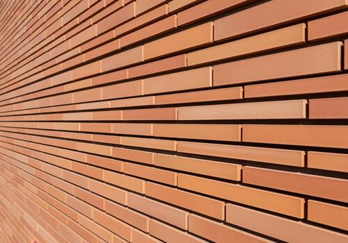 Contemporary stacked terracotta brick wall texture background with strong linear perspective. photo