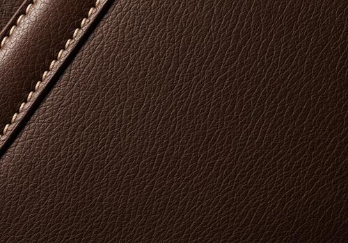 Rich dark brown leather texture background with diagonal seam and white stitching photo