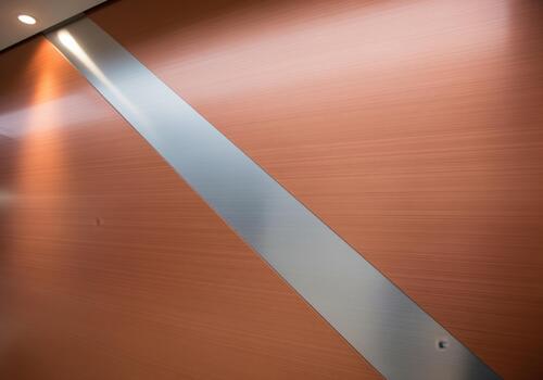 Abstract modern design featuring brushed copper texture and diagonal silver metal stripe photo