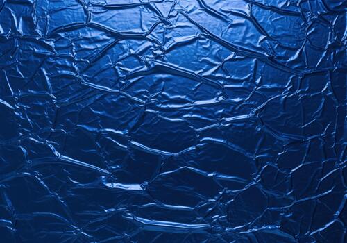 Captivating full frame abstract background of deep sapphire blue crumpled metallic foil. photo